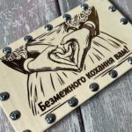 Коробочка з гвинтами для купюр відкрита, всередині видно відсік для купюр, поруч лежать металеві гвинти та гайки
