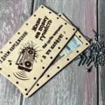 Відкрита дерев'яна коробочка з купюрами та розкрученими гвинтами і гайками