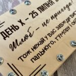 Крупний план гравіювання гумористичного побажання молодятам на дерев'яній пластині