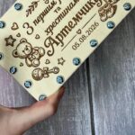 Дерев'яна подарункова коробочка для хрещеника з гравіюванням та гвинтами, що тримається в руці, демонструючи розмір та фактуру матеріалу