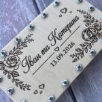 Крупний план гравіювання троянд та імен молодят на дерев'яному конверті для грошей