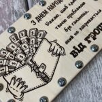 Крупний план гравіювання напису на дерев'яній коробці для грошей