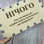 Дерев'яна коробочка для грошей на гвинтах у руці людини