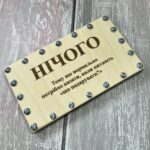 Дерев'яна коробочка для купюр на гвинтах, вид зверху на дерев'яній поверхні