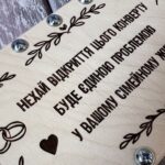 Крупний план лазерного гравіювання вітального тексту, серця та гілочок на дереві