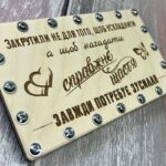 Лицьова кришка дерев'яного конверта з пам'ятним гравіюванням про справжнє щастя та кріпленнями на гайках