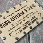 Закручена металевими гвинтами дерев'яна коробочка для весільного подарунка на дерев'яному тлі