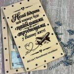 Відкрита дерев'яна коробочка з купюрами та розсипаними гвинтами і гайками