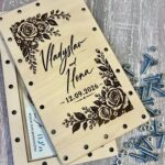 Відкрита дерев'яна коробочка з купюрами всередині та гвинтами з гайками поруч