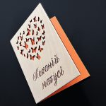 Листівка для матусі напіввідкрита: крізь метеликів видно помаранчеву підкладинку для слів від руки